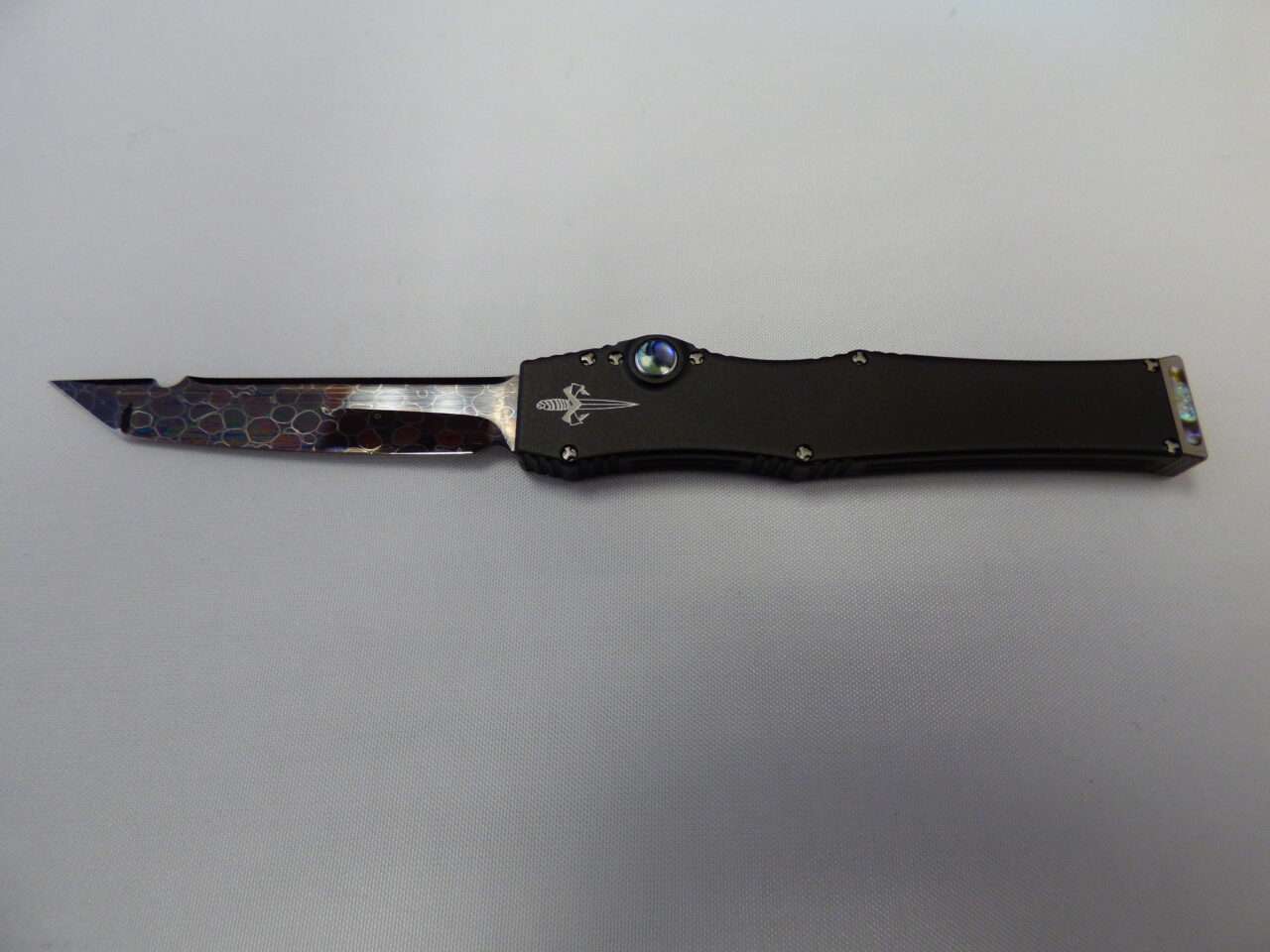 Microtech halo iii mini marfione custom hot blued dragon skin damascus tanto blade with black aluminum handle and abalone inlay button and inlay charging handle with double vapor blasted hardware blade facing left edge up